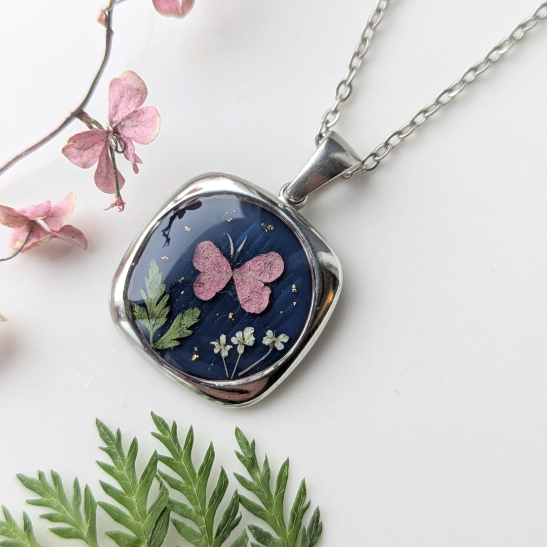 Handgefertigte Medaillon-Halskette, 1,8 cm – Blumen und Schmetterling in Harz mit Blattgold auf Dunkelblau